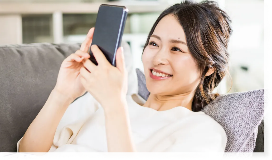 ソファーでスマホで動画を楽しむ人